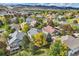 Aerial view of neighborhood showcasing lush landscaping, mature trees, and mountain views at 7360 S Owens Ct, Littleton, CO 80127