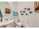 Charming powder room features a pedestal sink, oval mirror, and decorative wall accents at 7360 S Owens Ct, Littleton, CO 80127