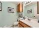 Bright half-bathroom with fresh paint, framed nautical art, and wood vanity at 7360 S Owens Ct, Littleton, CO 80127