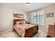 Comfortable bedroom with a wood bed frame, colorful bedding, and a shuttered window at 7360 S Owens Ct, Littleton, CO 80127