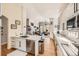 Bright kitchen featuring white cabinets, stainless steel appliances, quartz countertops, hardwood floors, and open-concept layout at 7360 S Owens Ct, Littleton, CO 80127