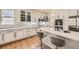 Bright kitchen featuring white cabinets, stainless steel appliances, quartz countertops, and hardwood floors at 7360 S Owens Ct, Littleton, CO 80127