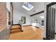 Dining room featuring hardwood flooring, skylights, and an exposed brick accent wall at 54 S Emerson St # 4, Denver, CO 80209