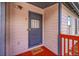 Entryway featuring a blue door, red porch, and a 