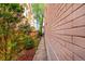 A narrow pathway between the house and fence, landscaped with trees and mulch at 54 S Emerson St # 4, Denver, CO 80209