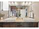 Elegant bathroom featuring double sinks with granite counters and decorative wood-look accent wall at 18083 Telford Ave, Parker, CO 80134