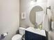 Charming powder room featuring a blue vanity and oval mirror at 18083 Telford Ave, Parker, CO 80134
