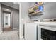 Functional laundry room with modern appliances and shelving for storage at 18083 Telford Ave, Parker, CO 80134