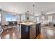 Bright, open living space with a kitchen island, dining area, and cozy living room featuring hardwood floors at 18083 Telford Ave, Parker, CO 80134