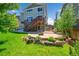 Landscaped backyard with lush green lawn, inviting patio and stairs to upper deck, highlighted by rocks and colorful flowers at 5722 S Flat Rock Way, Aurora, CO 80016