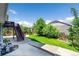 Well-maintained backyard featuring a lush lawn, concrete patio and stairs leading to an upper-level deck for outdoor enjoyment at 5722 S Flat Rock Way, Aurora, CO 80016