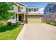 Beautiful two-story home featuring green siding, a stone facade, and a two-car garage at 5722 S Flat Rock Way, Aurora, CO 80016