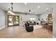 Open living room with hardwood floors, recessed lighting, glass door entrance, a large leather sofa and wet bar at 5722 S Flat Rock Way, Aurora, CO 80016