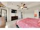 Bright main bedroom with a ceiling fan, large TV, and windows providing natural light at 5722 S Flat Rock Way, Aurora, CO 80016