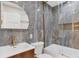 Modern bathroom with marbled tile, glass shower, and unique mirror adds sophisticated style and functionality at 1130 S Harrison St, Denver, CO 80210
