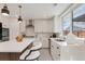 Modern kitchen with white cabinetry, stainless steel appliances, and cozy breakfast bar is move-in ready at 1130 S Harrison St, Denver, CO 80210