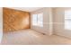 Spacious bedroom features carpet flooring, natural light from windows, and unique wood accent wall at 3512 S Kittredge St # C, Aurora, CO 80013