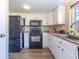 Updated kitchen features modern appliances, white cabinets, and brick backsplash enhancing its appeal at 3512 S Kittredge St # C, Aurora, CO 80013