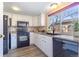 Charming kitchen features white cabinets, black appliances, stylish backsplash, and a window view at 3512 S Kittredge St # C, Aurora, CO 80013