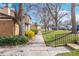 Sidewalk view with yellow and green bushes, trees, and glimpses of the neighborhood at 3512 S Kittredge St # C, Aurora, CO 80013