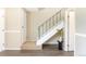 Entryway with staircase featuring wood-laminate floors, white stairs, and a black handrail at 3512 S Kittredge St # C, Aurora, CO 80013
