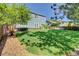 Inviting backyard features a lush green lawn, stone patio, and mature landscaping at 8416 S Reed St, Littleton, CO 80128