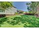 Expansive backyard features a lush lawn, mature trees, and a stone patio, ideal for relaxation at 8416 S Reed St, Littleton, CO 80128