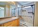 Bright bathroom features a marble walled shower with glass door and sleek hardware at 8416 S Reed St, Littleton, CO 80128