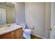 Powder room featuring a classic vanity with a sink, toilet, and neutral wall color at 8416 S Reed St, Littleton, CO 80128