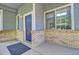 Cozy front porch featuring brick accents, a blue front door, and an inviting entry space at 8416 S Reed St, Littleton, CO 80128