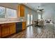 Open concept kitchen with wood cabinets, stainless steel dishwasher and views to dining and living area at 8416 S Reed St, Littleton, CO 80128