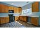 This kitchen has wood cabinets, black appliances, and plenty of natural light at 8416 S Reed St, Littleton, CO 80128