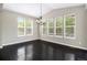 Bright dining area with large windows, dark hardwood floors, and a modern chandelier at 3522 Harvard Pl, Broomfield, CO 80023