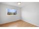 Serene bedroom with pristine white walls, hardwood floors, and a large window offering a pleasant outdoor view at 1544 E Weldona Way, Superior, CO 80027