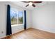 Bedroom includes a large window with nature views, hardwood floors, and ceiling fan at 1544 E Weldona Way, Superior, CO 80027
