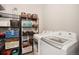 Organized laundry area with shelving, baskets, and a modern washer and dryer for efficient home convenience at 2279 E 129Th Ave, Thornton, CO 80241