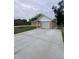 Exterior view shows the house with a long concrete driveway and attached garage at 8220 E 104Th Way, Henderson, CO 80640