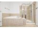 Bathroom features tiled floors, a tub with tile surround, and a glass enclosed shower at 11972 W Long Cir # 204, Littleton, CO 80127