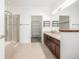 Bathroom features tiled floors, double sink vanity, tub with tile surround, and glass enclosed shower at 11972 W Long Cir # 204, Littleton, CO 80127