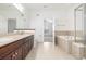 Bathroom features tiled floors, double sink vanity, a tub with tile surround, and a glass enclosed shower at 11972 W Long Cir # 204, Littleton, CO 80127