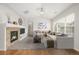 Staged living room features fireplace with stone surround, plush carpeting and large window with natural light at 11972 W Long Cir # 204, Littleton, CO 80127