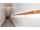 Bright staircase with carpeted steps and a wooden handrail against a white wall at 11972 W Long Cir # 204, Littleton, CO 80127