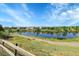 Community featuring a beautiful lake view with a walking path, trees, and blue skies at 12793 Leyden St # D, Thornton, CO 80602