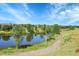Scenic community lake view with walking trail, playground, and lush trees at 12793 Leyden St # D, Thornton, CO 80602