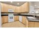Kitchen showcasing light wood cabinets, black countertops, and white appliances at 12793 Leyden St # D, Thornton, CO 80602