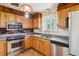 Efficient kitchen featuring stainless steel appliances, wood cabinetry, modern countertops, and a view of the backyard at 541 Yucca Hills Rd, Castle Rock, CO 80109