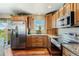 Kitchen featuring stainless steel appliances, granite countertops, wood cabinets and floors at 4295 S County Road 193, Byers, CO 80103