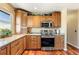 Modern kitchen features wood cabinets, granite counters, stainless steel appliances and oven at 4295 S County Road 193, Byers, CO 80103
