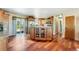 Bright kitchen featuring wood floors, an island with glass door cabinets, and a sliding glass door to the backyard at 4295 S County Road 193, Byers, CO 80103