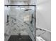 Stylish bathroom showcasing a marble-tiled shower with matte black hardware and a tiled shower floor at 12215 Viewpoint Dr, Lakewood, CO 80401